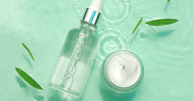 Serum and moisturizer on green water background